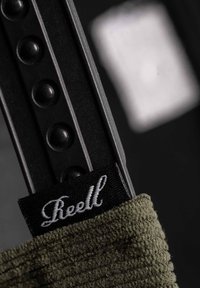 Reel Markenriemen aus olivgrünem Stoff; verfügt über schwarze Beschläge mit erhabenen Punkten; strukturierte Oberfläche mit einem gestickten Logo-Tag.