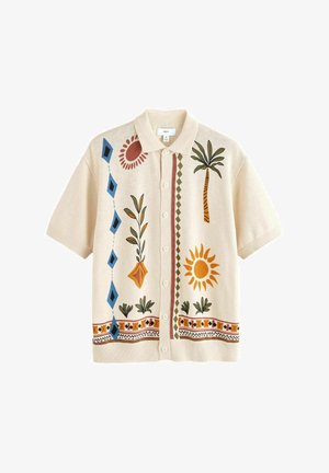 Īsi piedurkņu krēmkrāsas jaka ar krāsainu ziedu un ģeometrisku izšuvumu, ar pogu aizdari un klasisku apkakli.