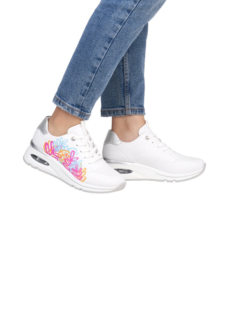 White sneakers with a multicolor floral design on the outer side, featuring silver accents and a thick sole with air cushioning.