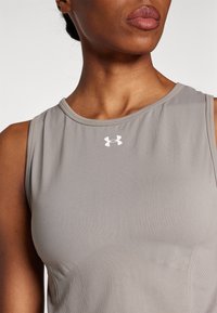 Šedý atletický top bez rukávů z hladké látky, s kulatým výstřihem a malým bílým logem Under Armour uprostřed.