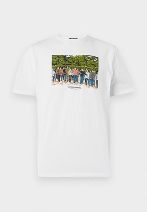 T-shirt en coton blanc avec un imprimé graphique coloré représentant des personnes devant des arbres, avec le texte "WEEKEND OFFENDER" en dessous de l'image.