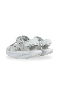 Sandalias blancas con un diseño transpirable, recortes, correas ajustables y una suela acolchada para mayor comodidad. Textura suave en todo su recorrido.