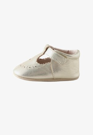 Piccola scarpa da bambino dorata metallica con bordi smerlati, ritagli a forma di cuore e chiusura con strap in velcro.