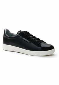 Black leather sneaker with perforated detailing, round toe, black laces, and a white rubber sole. Features subtle branding on the side.