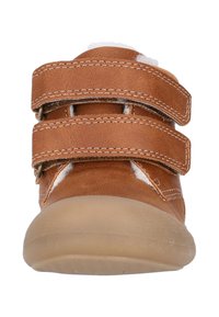 Chaussure en cuir marron avec deux sangles Velcro ajustables. Présente une forme arrondie et une semelle en caoutchouc de couleur claire avec une texture antidérapante.