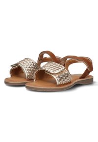 Metallic guld vævede sandaler med brune accenter; åben design, flad sål og dobbelte stropper til at sikre foden. Glat læder indersål.