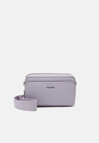Borsa a tracolla lilla realizzata in materiale sintetico morbido, con chiusura a zip, tracolla staccabile e logo del marchio impresso sul davanti.