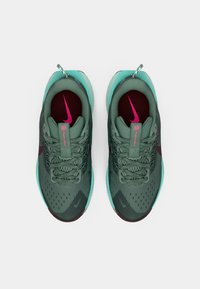 Rohelised spordijalatsid, millel on võrkkate, türkiissinised aktsendid, tumepunased sisetallad ja roosa Nike logo. Omab tekstureeritud paelu ja kontsakaid.