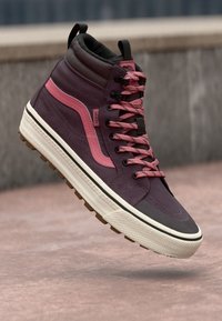 Høye sneakers i mørk lilla semsket skinn, med rosa detaljer og kontrastfarget hvit gummisåle. Har rosa lisser og polstret krage.