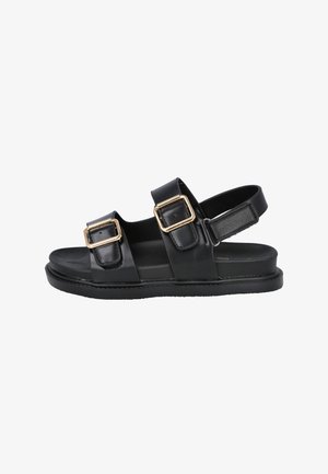 Sandalias de cuero negro con dos correas, con hebillas doradas. Suela plana y diseño de parte trasera abierta para facilitar su uso. Textura suave.