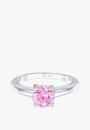 Bague en argent avec une pierre précieuse rose ronde et facettée sertie dans quatre griffes au centre de l’anneau.
