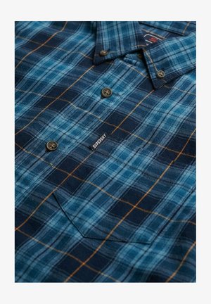 Blue and black plaid button-up shirt with brown lines, a chest pocket, and a small "Superdry" tag on the front.