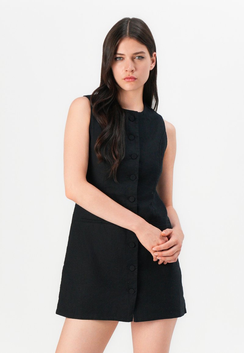 Schwarzes ärmelloses Kleid mit durchgehender Knopfleiste, kragenlosem Design, Seitentaschen und glatter Textur.