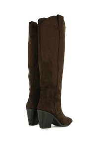 Botas marrón de ante hasta la rodilla con un borde superior en forma de onda, punta cuadrada y un tacón grueso negro. Las costuras verticales acentúan el diseño.