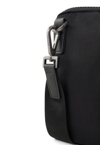 Borsa nera in nylon con clip a moschettone in metallo, tessuto testurizzato e una larga tracolla nera con un accento in pelle.