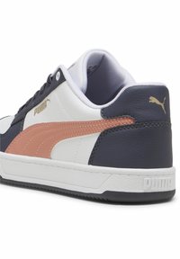 Weiße und marineblaue Sneaker mit glatter Textur; verfügen über einen Pfirsichstreifen und goldene Logoakzente an der Ferse und der Seite. Gepolsterte Kragenkonstruktion.