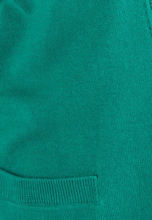Groene gebreide stof met een gestructureerd oppervlak, met een zichtbare pocket en ribbelaccenten langs de randen. Gladde, zachte textuur.