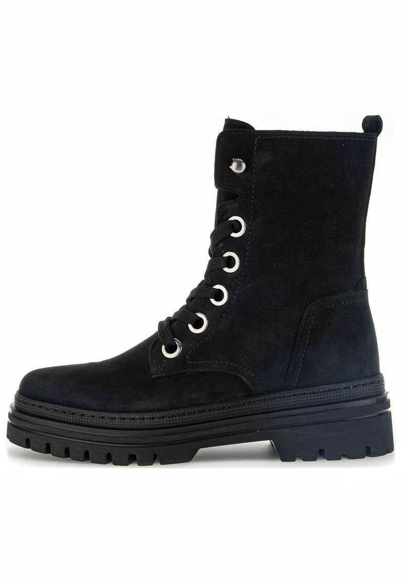 Stivaletto alla caviglia in suede nero con punta rotonda, lacci davanti, occhielli in argento e suola in gomma nera robusta. Presenta un'etichetta sul retro.