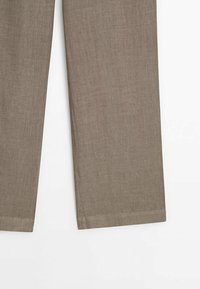 Pantalon en lin brun avec une coupe droite, doté d'une texture lisse et d'un ourlet soigné. Simple et polyvalent pour diverses occasions.