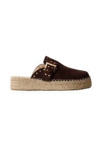 Zapato marrón de ante tipo slip-on con hebilla dorada y tachuelas, con suela plataforma de yute trenzado grueso y costuras blancas alrededor de los bordes.