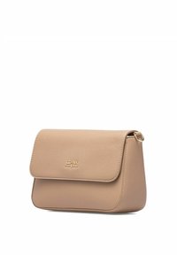Beżowa skórzana torebka na ramię z klapką, o zaokrąglonym kształcie, złotym logo z przodu i subtelnym teksturowanym wykończeniu. Posiada boczną pętlę na akcesoria.