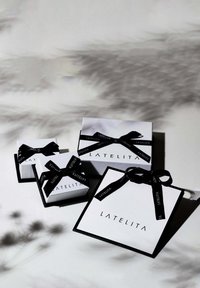 White gift boxes with black bands, featuring the brand "LATELITA." Sizes vary; smooth texture, minimalist design, and black accents.
