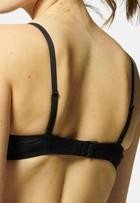 Zwarte bh met verstelbare banden; heeft een haak-en-oogsluiting. Soepele textuur met minimale naden, ontworpen voor comfort en ondersteuning.