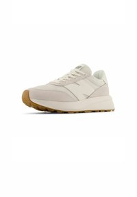 Sneaker in crema e grigio chiaro, con un mix di tessuto e suede, suola spessa e suola in gomma marrone chiaro. Due strisce laterali.