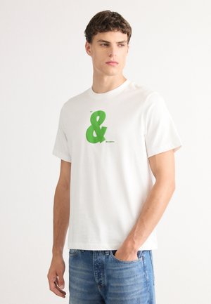 White cotton t-shirt with short sleeves, featuring a large green ampersand logo on the chest and a small text detail beneath.