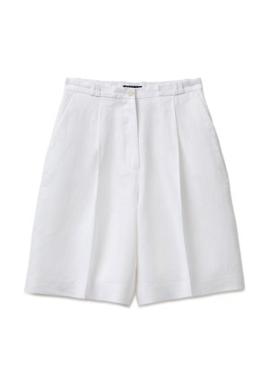 Shorts blancs sur mesure longueur genoux avec plis devant, passants de ceinture, poches latérales et fermeture par bouton à la taille.