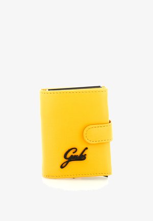 Portafoglio in pelle gialla con chiusura a scatto e logo nero "Gabs" sul davanti su sfondo bianco.