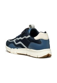 Zapato deportivo en azul marino y azul claro con parte superior texturizada, acentos blancos en contraste y suela acolchada. Presenta una tira en la parte trasera para facilitar el calzado.