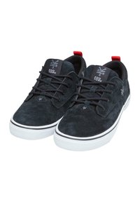 Fekete velúr sneaker fehér gumitalppal, fekete fűzővel és piros saroktáblával. Jellemzője egy logós címke a nyelvén és egy textúrált felsőrész.