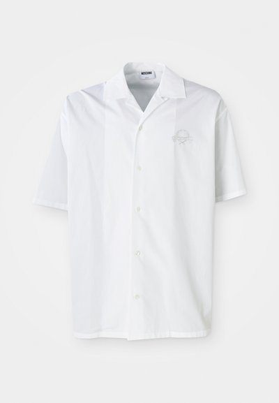 Fehér, rövid ujjú ing hegyes gallérral, gombos elülső résszel és hímzett mintával a bal mellrészen. Sima szövet textúra.