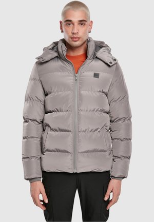 Chaqueta de plumas gris con capucha, con cierre de cremallera en la parte delantera y puños elásticos. Fabricada con un material suave y brillante con un diseño acolchado.