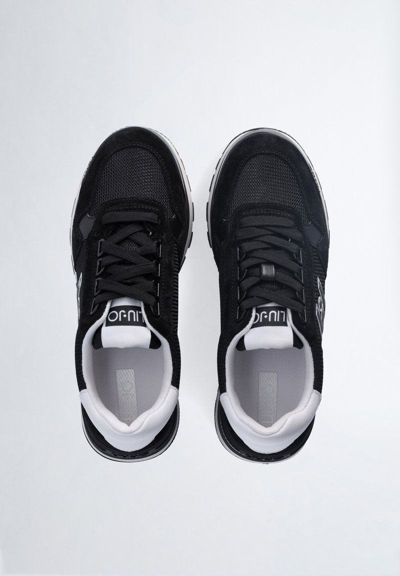 Sneaker sportive nere realizzate in mesh e suede, con una tomaia testurizzata, suola bianca e lacci tonali. Logo visibile sul lato.