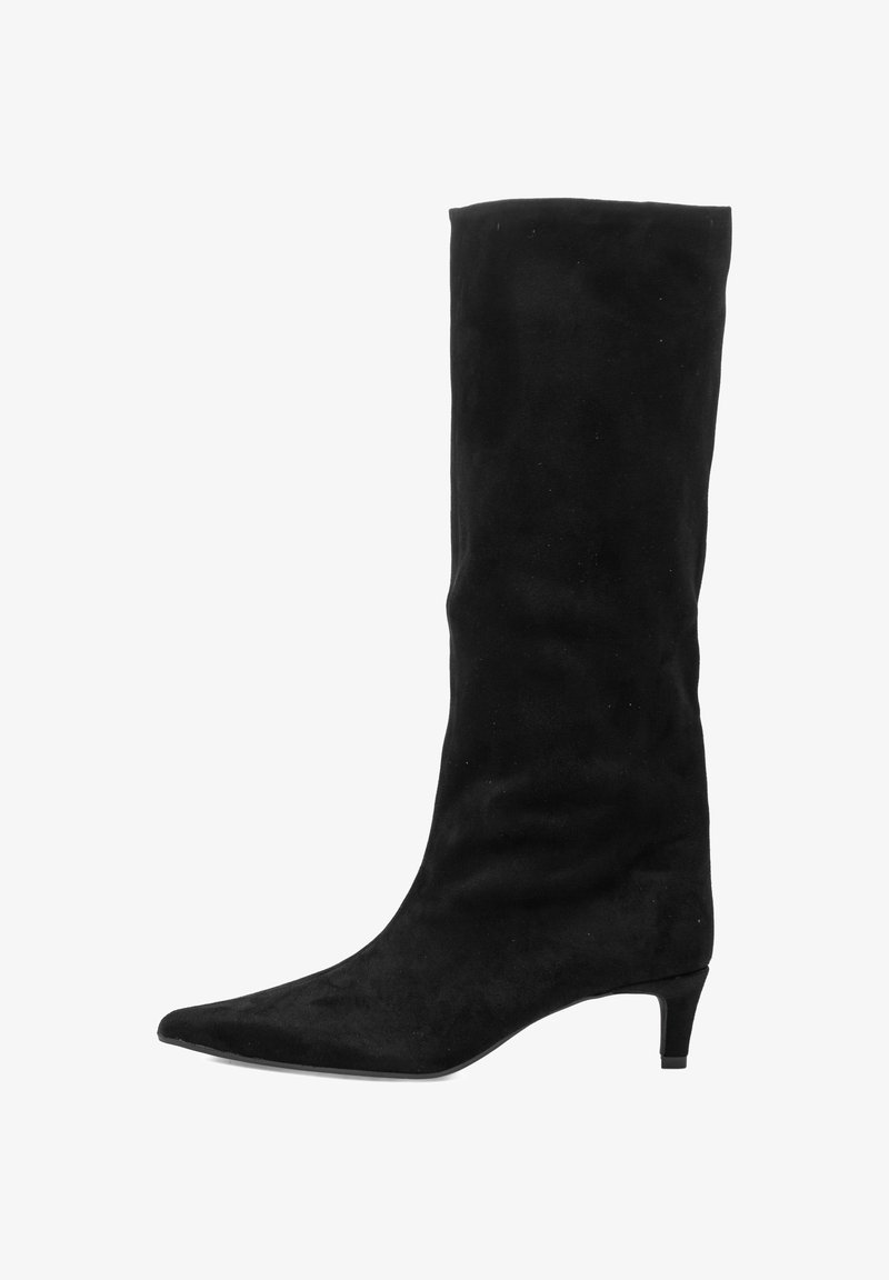 Bota de ante negra hasta la rodilla con punta afilada y tacón bajo en forma de kitten, de pie sobre un fondo blanco.