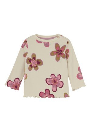 Cremefarbens Langarm-Babyschirt mit gewellten Kanten und floralen Mustern in Rosa, Lila und Grün, mit einem Knopfverschluss an der Schulter.
