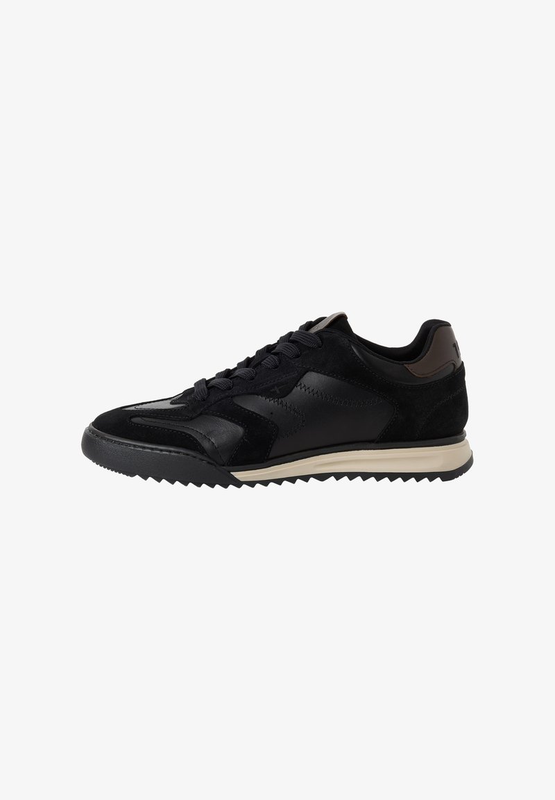 Μαύρο χαμηλό sneaker με πάνελ από σουέντ και δέρμα, μαύρα κορδόνια, ραβδωτή μαύρη σόλα και μπεζ λωρίδα στη μεσαία σόλα.
