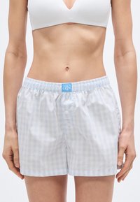 Ανοιχτόμπλε και λευκά καρό σορτς από ελαφρύ ύφασμα, με ελαστική μέση, κούμπωμα με κουμπιά και πλαϊνές σχισμές.