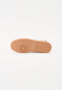 Gumi talpú sneaker, texturált mintával, kör- és hexagonális formákkal. Szín: bézs, feltűnő márkázással.