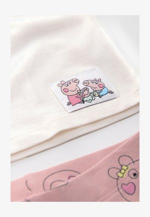 Top in cotone beige con toppa logo raffigurante maialini in versione cartone animato. Fondo rosa con stampa di facce di maiale, evidenziato da accenti gialli. Texture morbida.