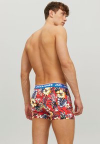 Rote Boxer-Briefs mit einem lebhaften Blumenmuster und einem blauen Bund, der den Markennamen "JACK & JONES" zeigt.