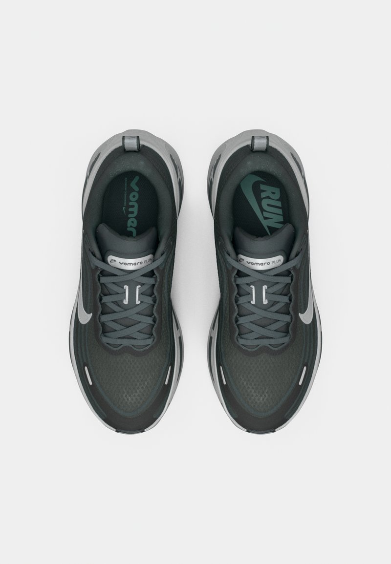 Graue Sportschuhe mit einer strukturierten Oberseite, versehen mit einem Schnürdesign, weicher Dämpfung und einem silbernen Swoosh-Akzent. Gummisohle für Trittsicherheit.