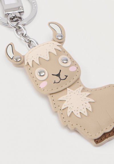 Μπρελόκ λάμα από μπεζ συνθετικό δέρμα με μεταλλικά μάτια, αυτιά και αλυσίδα, με ραμμένες λεπτομέρειες και ροζ μάγουλα.