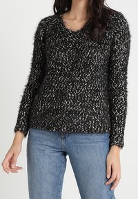 Czarny i biały, puszysty sweter z okrągłym dekoltem i długimi rękawami, z teksturowanym wzorem i luźnym krojem.