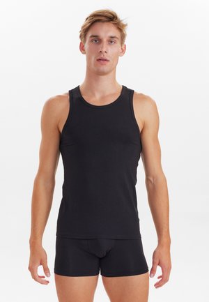 Sort bomulds tank top med brede skulderstropper, parret med sorte boxer shorts. Enkel design, glat tekstur og tætsiddende form.