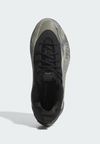Sneaker nera con tomaia in tessuto testurizzato, intersuola traslucida e punta arrotondata. Caratterizzato da un sistema di lacci e un piccolo manico sul tallone.