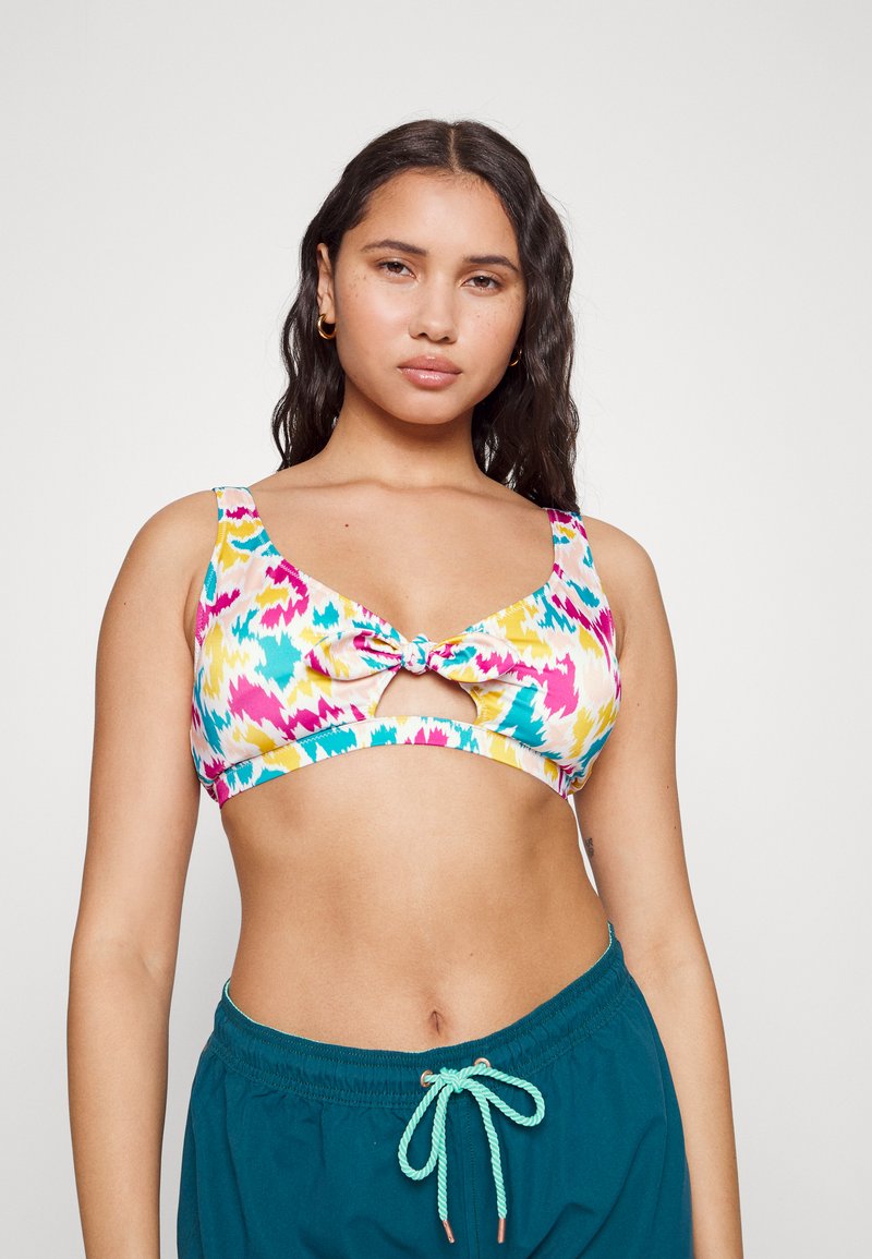 Top de biquíni colorido com um padrão em zigzag multicolorido em rosa, amarelo e verde-água, com detalhe de nó na frente e alças largas.