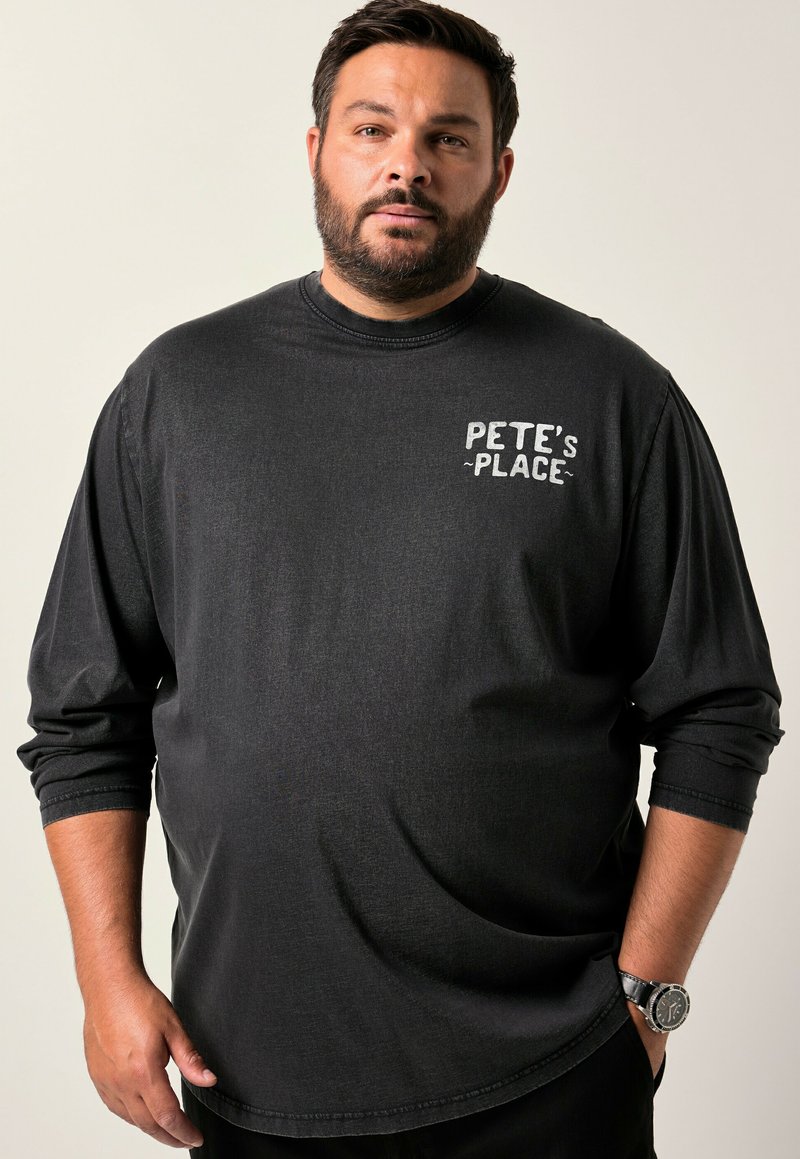Svart långärmad t-shirt med vit text "PETE'S PLACE" på vänster bröst. Mjuk tygkvalitet med en avslappnad passform och rundad nederkant.